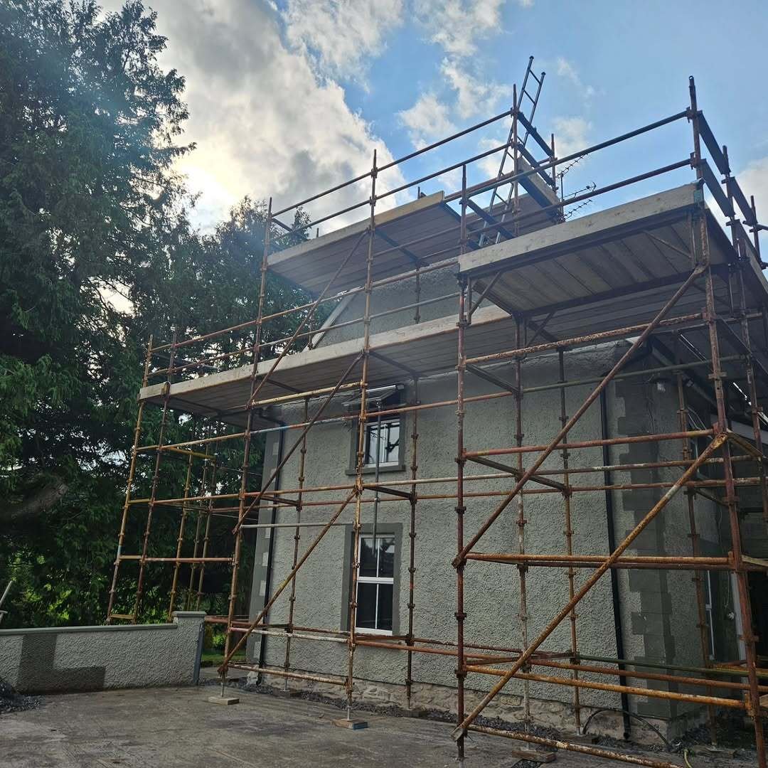 Two-storey pebbledash house in Co. Monaghan wrapped in multi-level scaffolding for exterior access