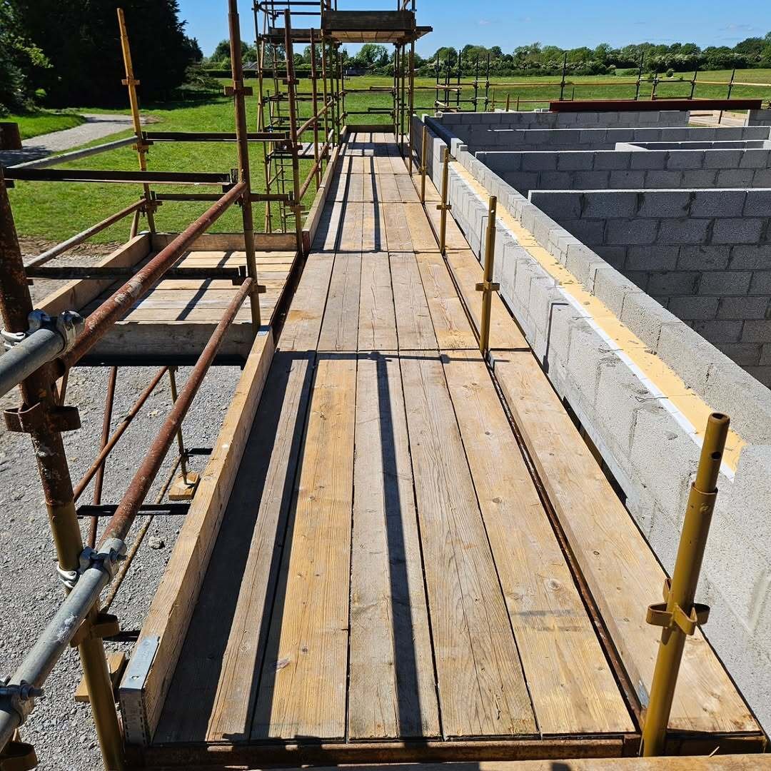 Boarded scaffolding walkway running beside rising concrete block walls on the Kiltale dormer build