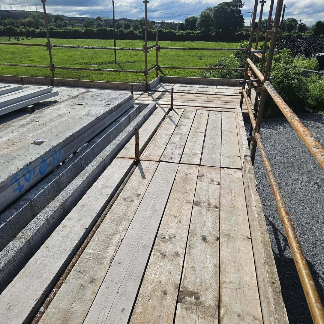 Boarded scaffold platform beside hollowcore concrete floor units on a rural Limerick new build