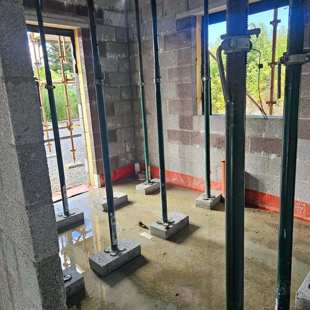 Adjustable steel props supporting a concrete floor inside a blockwork new build in Limerick