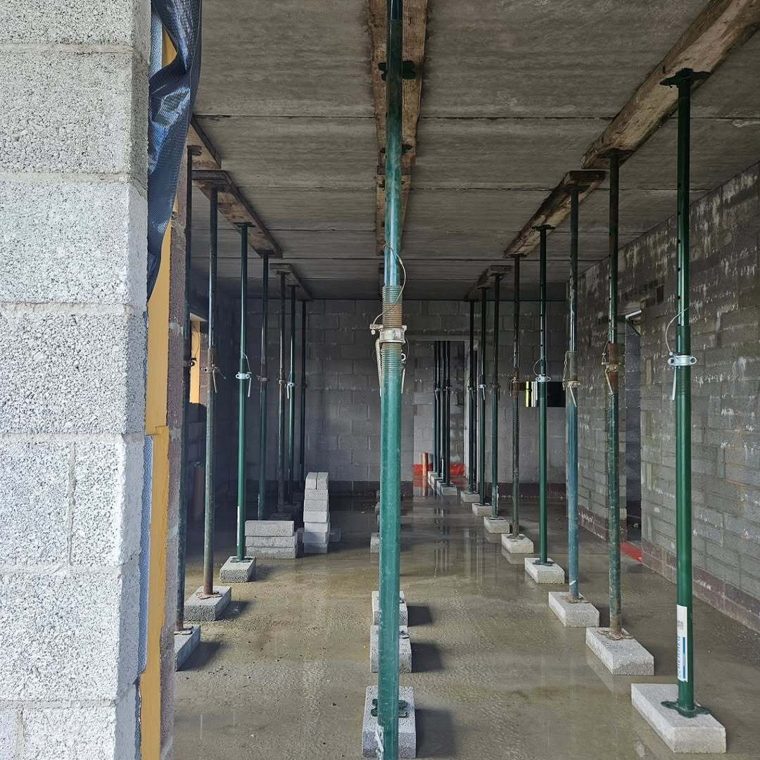 Rows of steel props supporting the concrete first-floor slab during construction