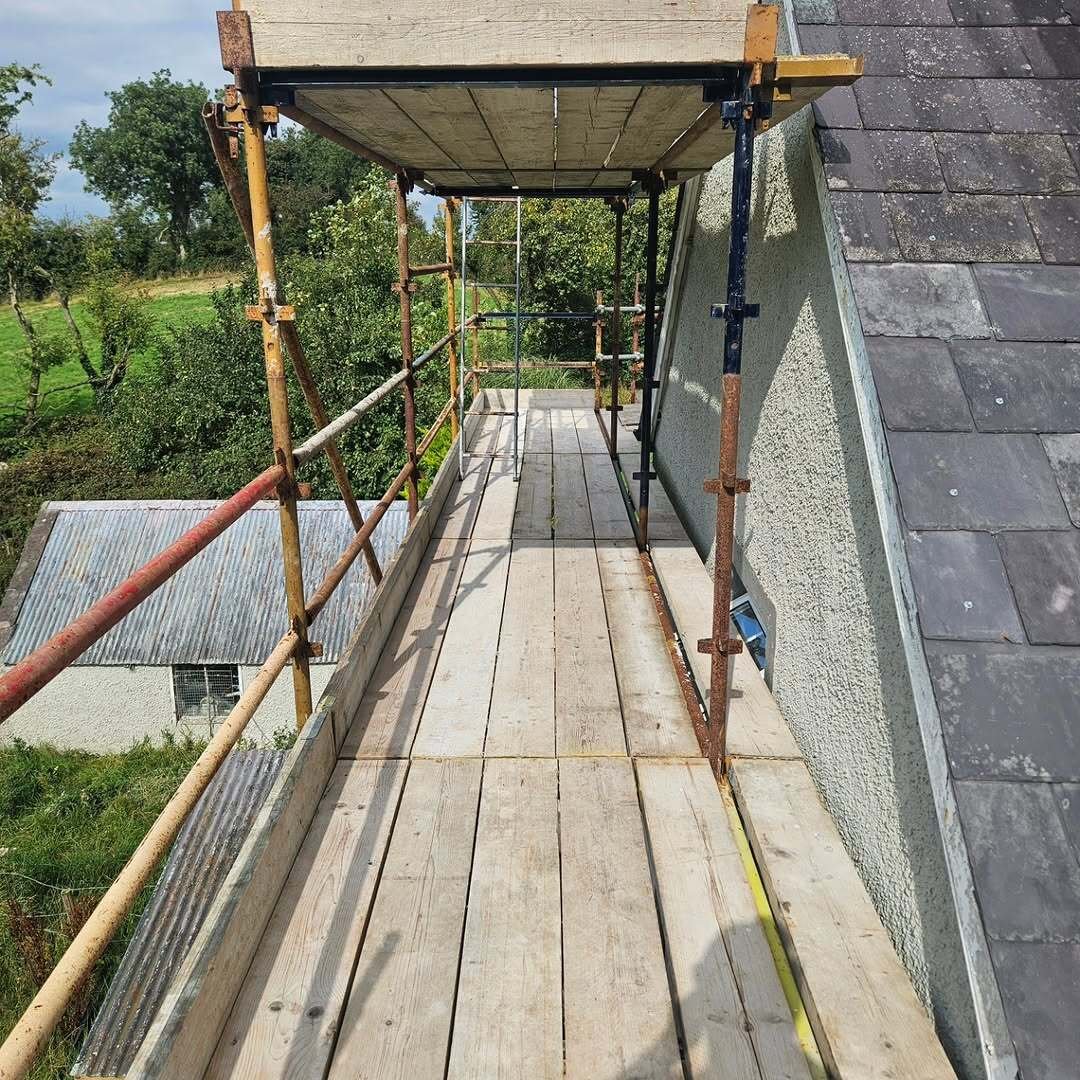 Scaffold walkway along the gable of a two-storey home overlooking rural fields in Co. Monaghan